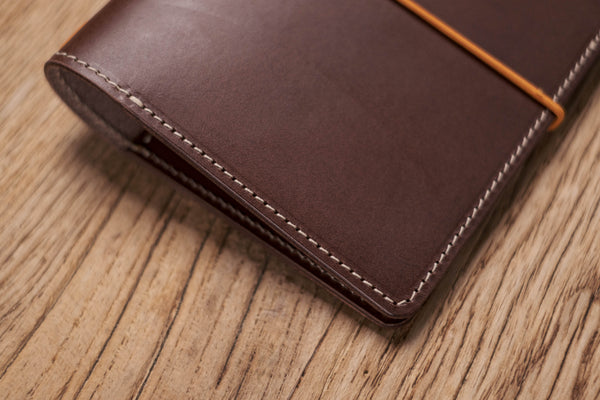 A brown Stitched Buttero Leather Traveler's Notebook and a elastic enclouse, Close up of stitching