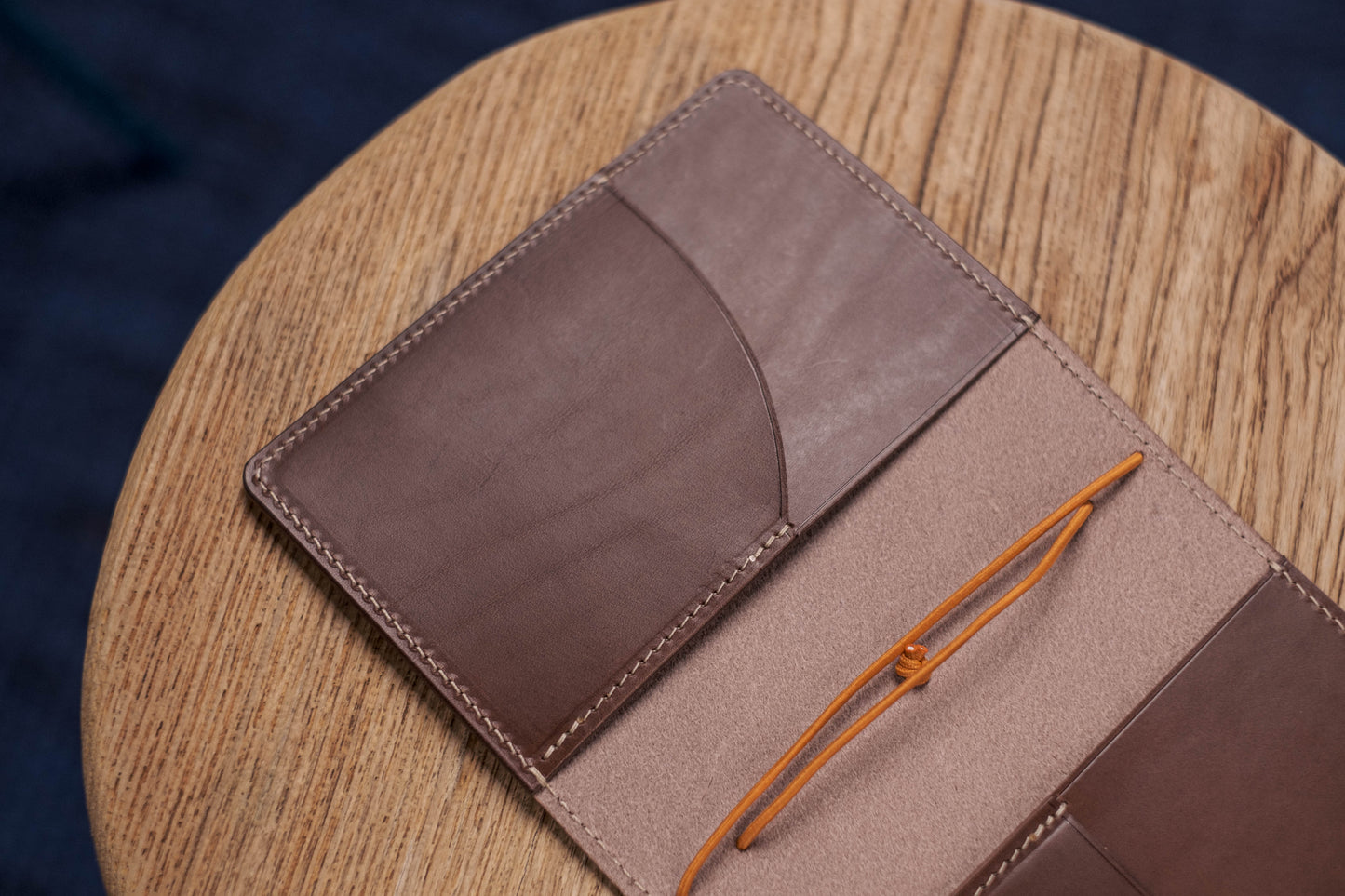 A brown Stitched Buttero Leather Traveler's Notebook and a elastic enclouse, displayed open, close up for inside left pocket