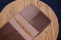 A brown Stitched Buttero Leather Traveler's Notebook and a elastic enclouse, displayed open, close up for inside right pocket