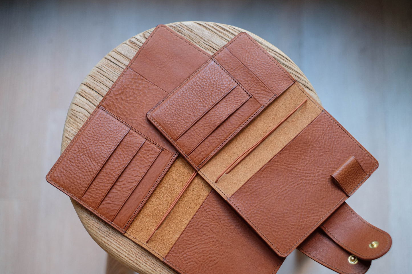 Two orange brown leather traveler's notebook with card slots and a snap button closure, displayed open